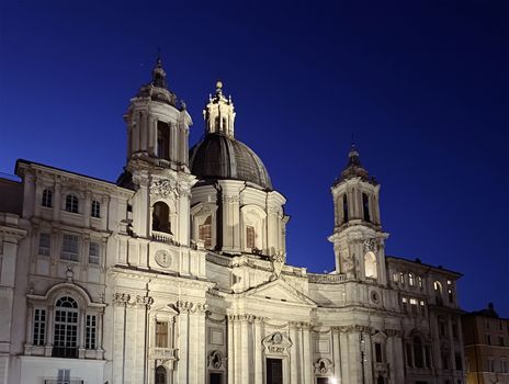the facade of the baroque church of Sant'Agnese in Agone in Piazza Navona in Rome illuminated at night. Travel destination and Roman Baroque style. Christianity and religion