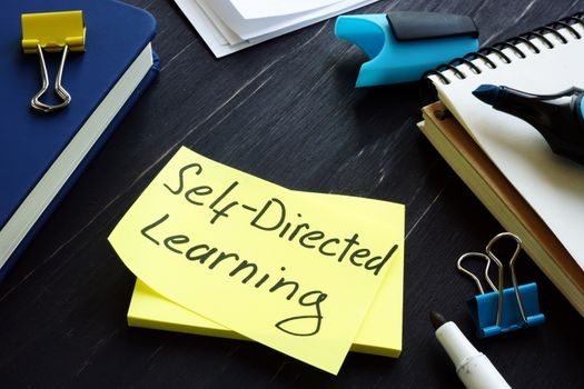 Self-directed learning or education concept. Book and notes with pen.