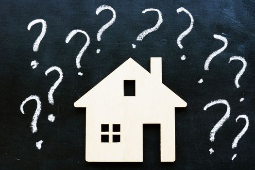 Question marks and model of home. Mortgage or buy and rent property.