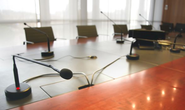 microphone on a wooden table and empty chairs in a boardroom. Business concept