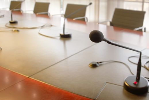 microphone on a wooden table and empty chairs in a boardroom. Business concept