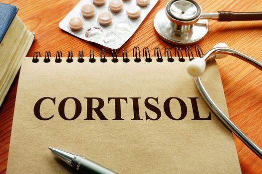 Cortisol hormone on the sheet with stethoscope and book.
