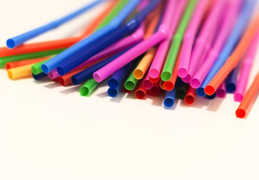 a group of colored plastic cocktail straws. Plastic and non-recyclable materials. Pollution and environmental issues