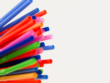 a group of colored plastic cocktail straws. Plastic and non-recyclable materials. Pollution and environmental issues