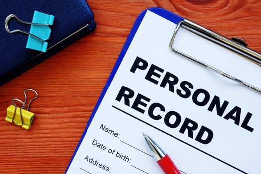 Personal records information form and other papers with pen.