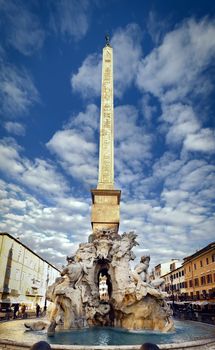 the fountain of the four rivers designed by Bernini in the center of Piazza Navona in Rome on a sunny winter day. The Baroque fountain represents the major known rivers of that era.