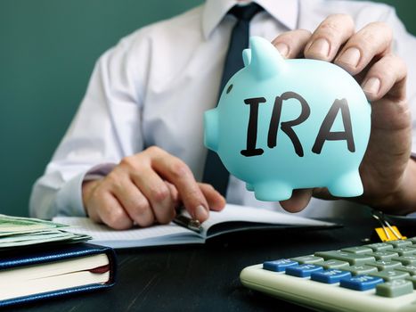 IRA Individual Retirement Account concept. Manager proposes piggy bank.