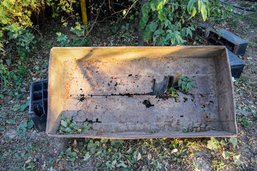 Old rusty holey steel trough. Scrap metal is rusty.