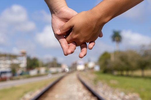 Given hands of two people on the train line