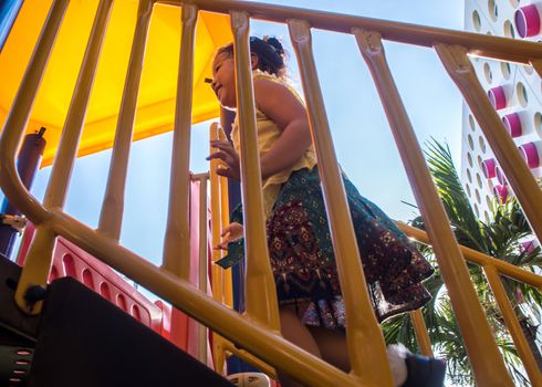 Asian little girl enjoys playing at children playground in leisure time