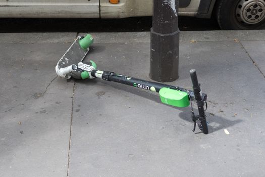 Broken electric scooter on the road in Paris, France 10-9-19. This depict 2 major ecological problems : planned obsolescence and short term use objects