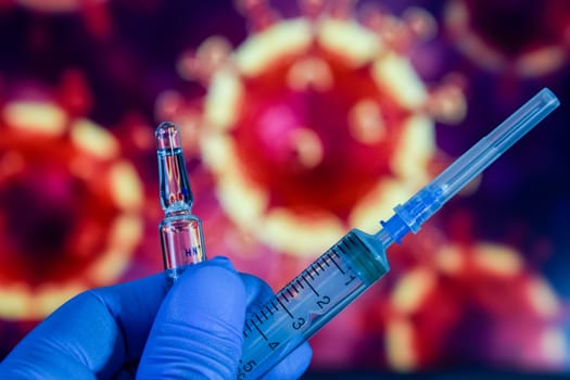 Coronavirus vaccine. A hand in medical gloves holds a vaccine and a syringe against the background of the image of a coronavirus. covid-19,