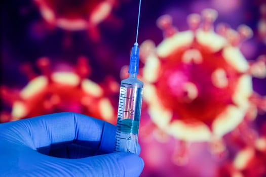 Coronavirus vaccine. A hand in medical gloves holds a vaccine and a syringe against the background of the image of a coronavirus. covid-19,