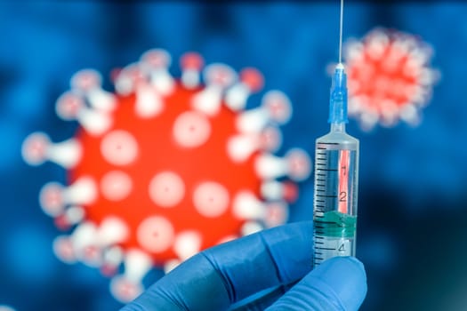 Coronavirus vaccine. A hand in medical gloves holds a vaccine and a syringe against the background of the image of a coronavirus. covid-19,