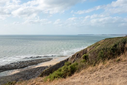 Normandy coast, this traditional landscape with green sea, and blue sky wth little clouds is a typical view of north part of france