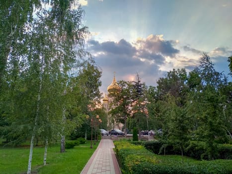 Park landscape, view of the church at sunset. Evening park.