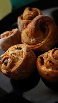 Chicken rolls from puff pastry on a black plate - vertical photo