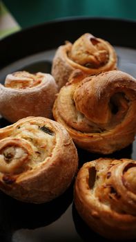 Chicken rolls from puff pastry on a black plate - vertical photo