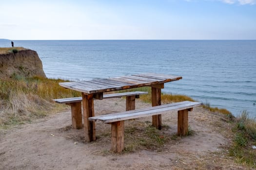 A table and benches by the sea. A place to sit and relax.