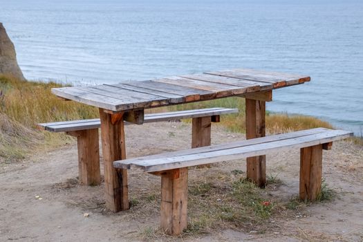 A table and benches by the sea. A place to sit and relax.