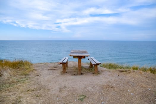 A table and benches by the sea. A place to sit and relax.