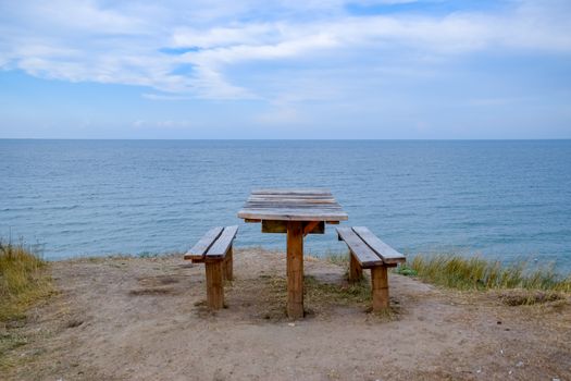 A table and benches by the sea. A place to sit and relax.