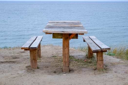 A table and benches by the sea. A place to sit and relax.