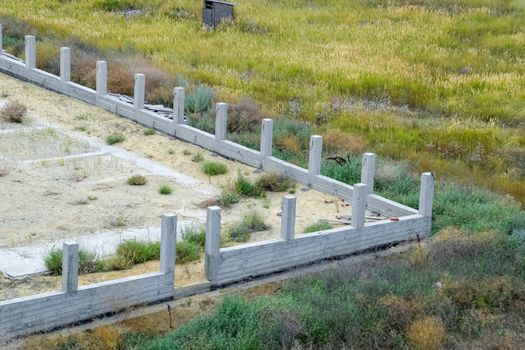 Concrete foundation of the future fence. Concrete fence, fence construction.