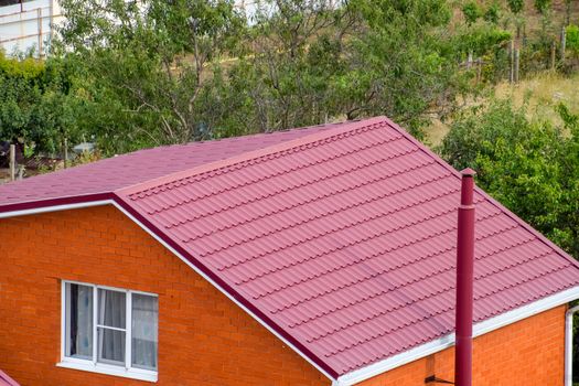 Roof made of metal. Construction with modern roofing materials. Corrugated metal profile.