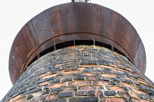 Rusty water tower against the sky. Old water pump.