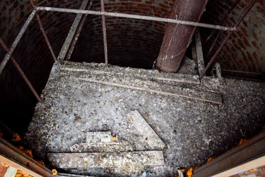 Rusty water tower inside view from top to bottom. Old water pump. Ladder to the water tank, pigeon droppings.