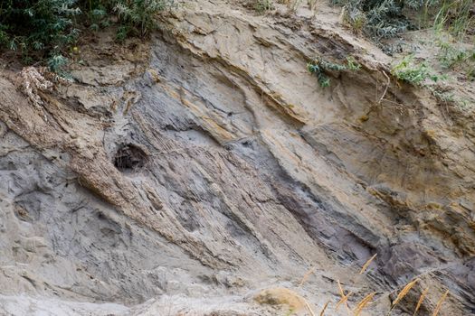 The sedimentary layers of the rock in the sand scree. sand, pebbles and shells in sedimentary rocks.