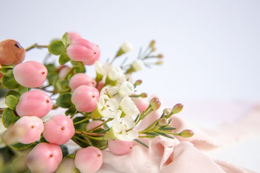 Peach flowers on a purple background with a peach silk ribbon. White and pink flowers. Macro image. Place for text. Greeting card. Mothers Day.