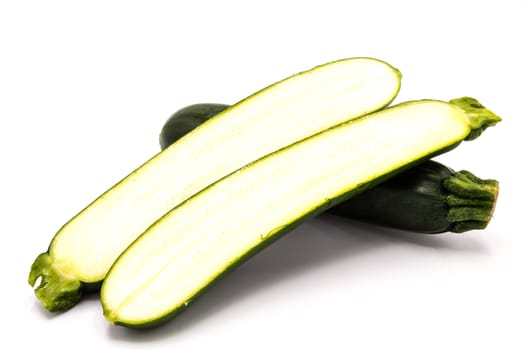 Close up on a fresh zucchini and cut in half on white background
