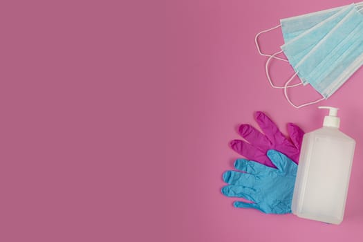 Medical gloves surgical mask, sanitizer gel - virus protection equipment on pink background. Pathogen respiratory coronavirus flu outbreak medical concept