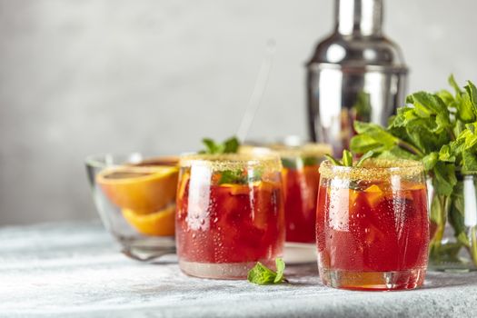 Italian aperol spritz cocktail with orange slices and ingredients on light gray stone table. Milano spritzer alcoholic cocktail with red bitter, dry white wine, soda, red orange and ice. 