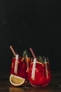 Two glasses of campari gin spritz. Cocktail of sweet, a touch of bitter from the campari and gorgeous fizz from the champagne topper. Dark background