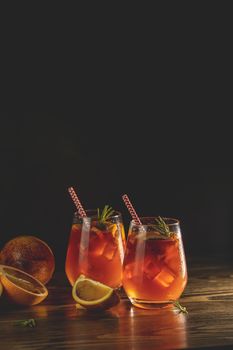 Two glasses with water drops of campari gin spritz. Cocktail of sweet, a touch of bitter from the campari and gorgeous fizz from the champagne topper. Dark background, amazing back light.