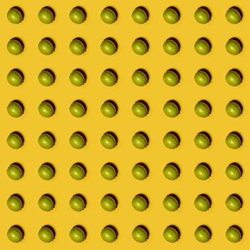 Limes pattern on yellow background. Creative food concept. Flat lay.