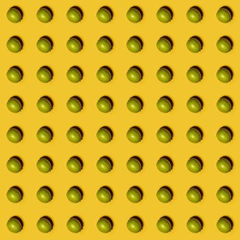 Limes pattern on yellow background. Creative food concept. Flat lay.