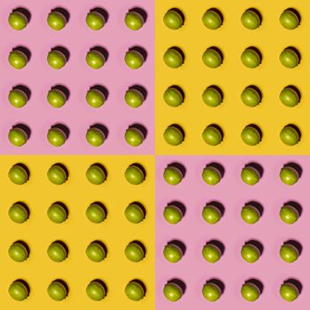 Limes pattern on yellow and pink background. Creative food concept. Flat lay.