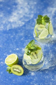 Two detox water or mojito. Summer bright drinks with mint. Refreshing drinks and juices from juicy fruits and mint. A new kind of mojito with kiwi, lime and mint and of course ice.