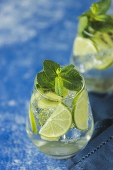 Two detox water or mojito. Summer bright drinks with mint. Refreshing drinks and juices from juicy fruits and mint. A new kind of mojito with kiwi, lime and mint and of course ice.