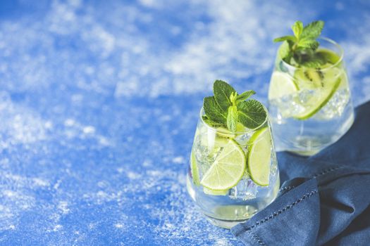 Two detox water or mojito. Summer bright drinks with mint. Refreshing drinks and juices from juicy fruits and mint. A new kind of mojito with kiwi, lime and mint and of course ice.