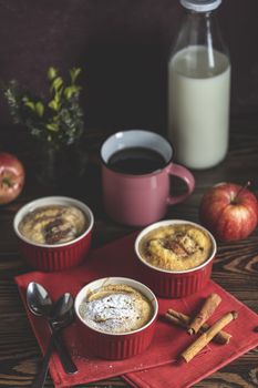Romantic breakfast or supper with coffee. Apple pie in ceramic baking molds ramekin on dark wooden table. Close up, shallow depth of the field.	