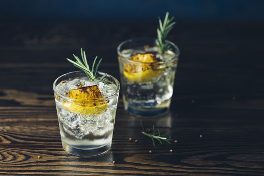 Charred Lemon, Rosemary and Coriander Gin and Tonic is a flavors are perfectly balanced refreshing cocktail. on dark background, close up. Summer drinks and alcoholic or detox cocktail