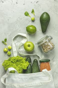 Zero waste concept. Eco-friendly shopping, flat lay. Fresh organic green vegetables and fruits on gray background. Spring diet, healthy raw vegetarian, vegan concept, alkaline clean eating.