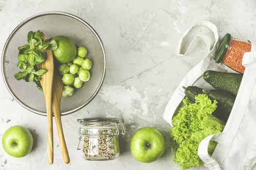 Zero waste concept. Eco-friendly shopping, flat lay. Fresh organic green vegetables and fruits on gray background. Spring diet, healthy raw vegetarian, vegan concept, alkaline clean eating