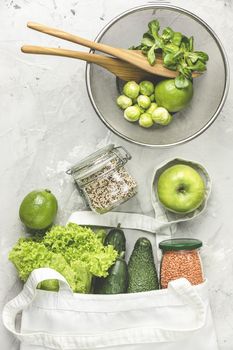 Zero waste concept. Eco-friendly shopping, flat lay. Fresh organic green vegetables and fruits on gray background. Spring diet, healthy raw vegetarian, vegan concept, alkaline clean eating