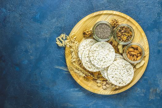 American puffed rice cakes. Healthy snacks with ears of wheat on classic blue concrete surface, top view, flat lay, copy space for you text. Color of 2020 year. Classic Blue, food trendy background.v